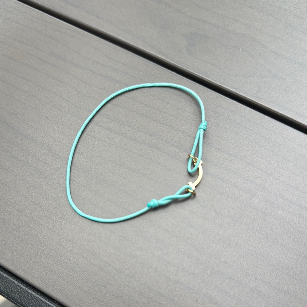 Tiffany T-smile bracelet. In yellow gold and blue cord